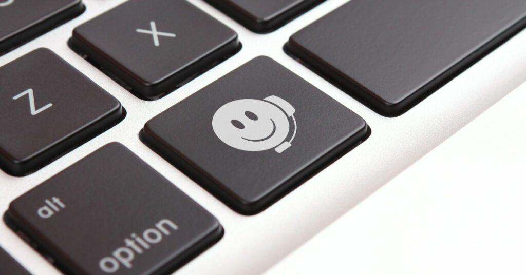 Keyboard showing an emoji with a virtual assistant customer service headset
